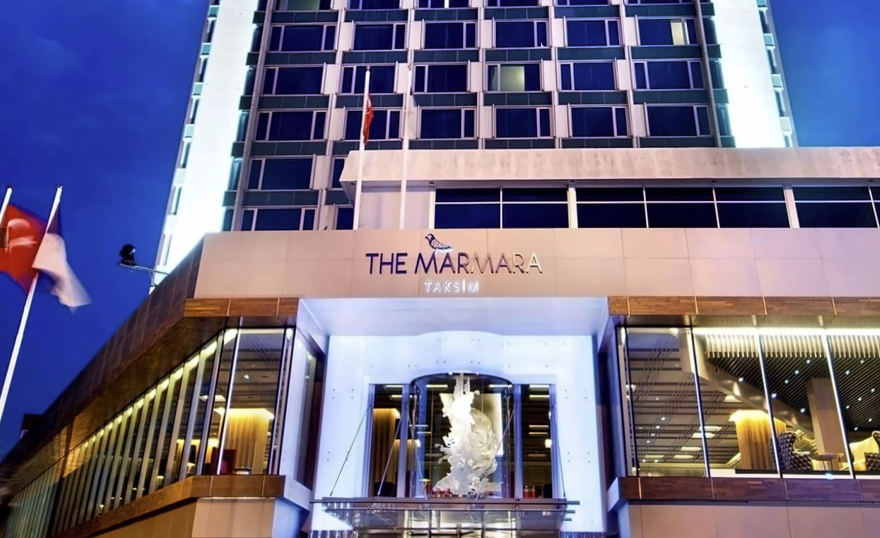 The Marmara Taksim Oteli giriş cephesinin gece aydınlatması altındaki görünümü